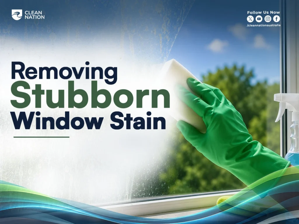 A person wearing a green cleaning glove uses a sponge to scrub stubborn stains from a glass window, with a spray bottle nearby, demonstrating Tips for Efficiently Cleaning Windows to remove tough marks and achieve a clear, streak-free finish.