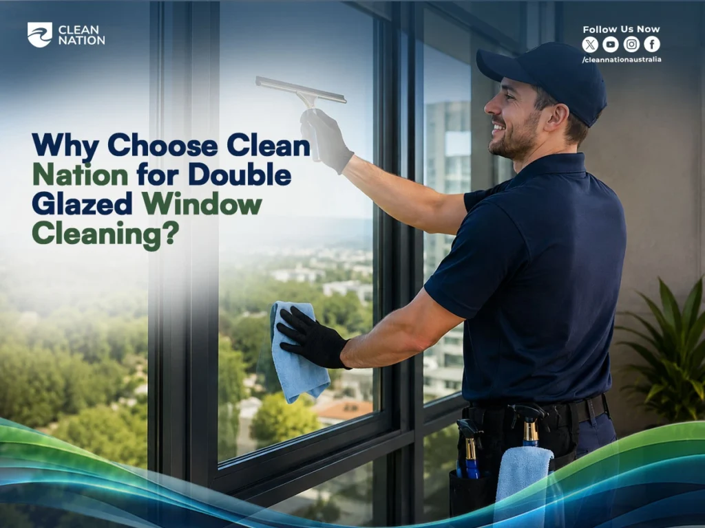 Professional window cleaner using a squeegee and microfiber cloth to clean large double glazed windows in a modern building, illustrating How to Clean Double Glazed Windows? safely and effectively with expert cleaning services from Clean Nation.