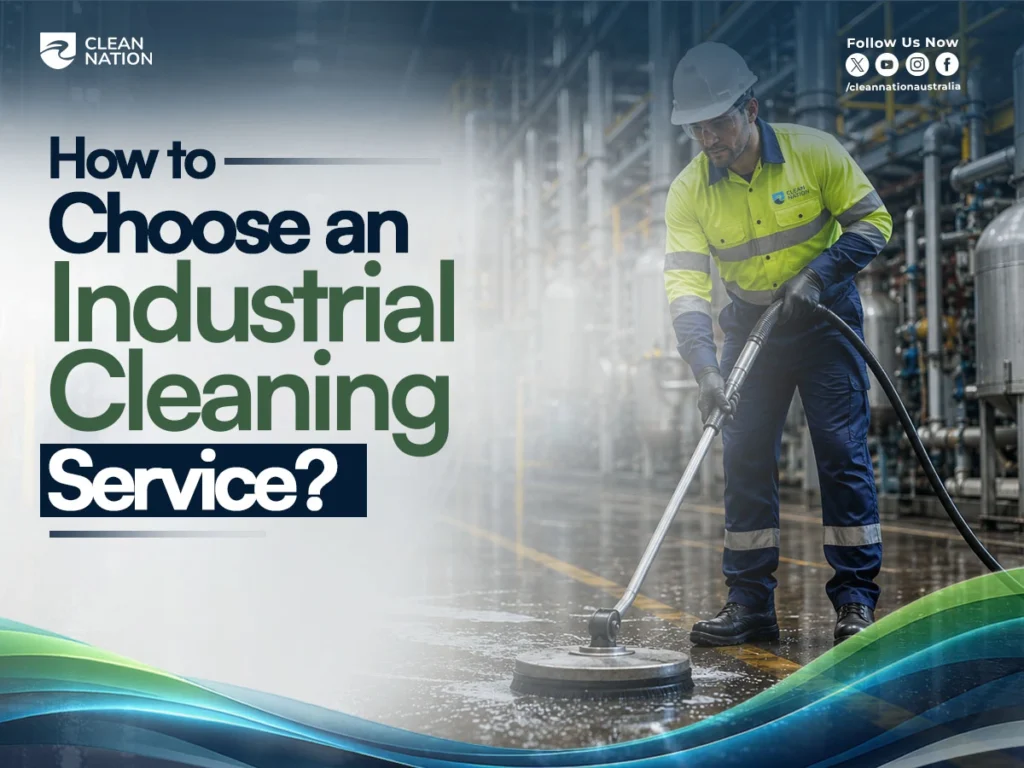 A Clean Nation industrial cleaner uses a floor scrubbing machine to clean a factory floor while wearing high-visibility safety clothing and protective equipment. The image illustrates How to Choose an Industrial Cleaning Service? by showcasing professional industrial cleaning in a safe manufacturing environment.