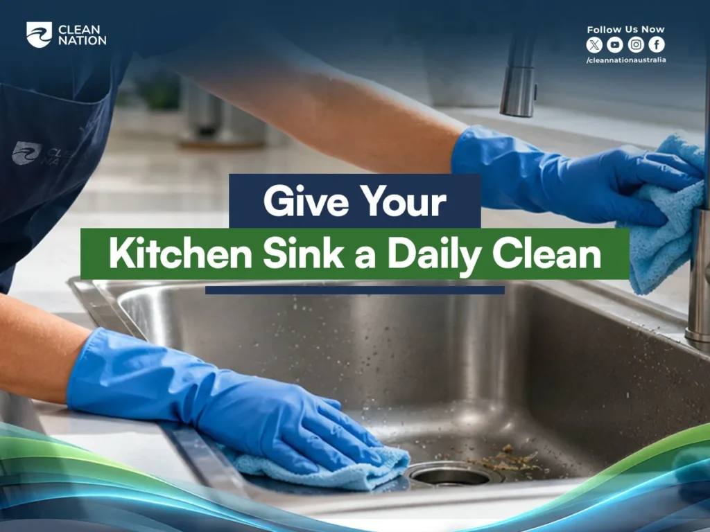 5 Professional Tips for a Cleaner kitchen, showing a professional cleaner wearing blue gloves and wiping a stainless steel kitchen sink with a microfiber cloth for daily hygiene.