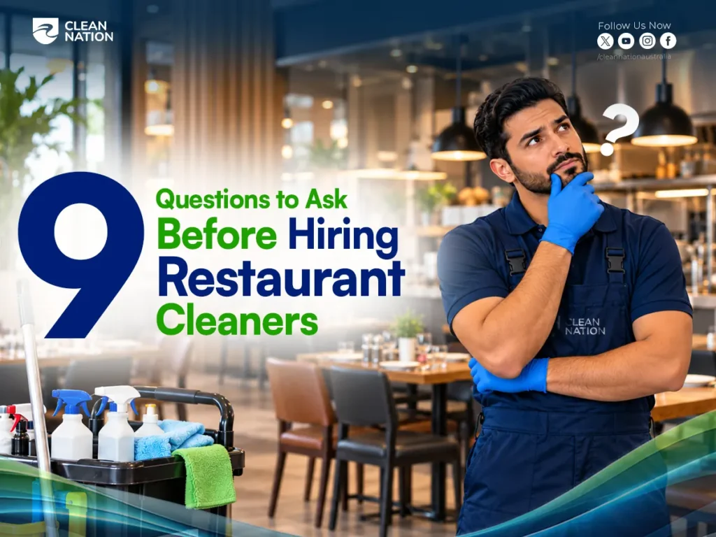 Clean Nation cleaner in an apron thinking with a question mark beside a cleaning trolley, in a restaurant, with questions to ask before hiring restaurant cleaners