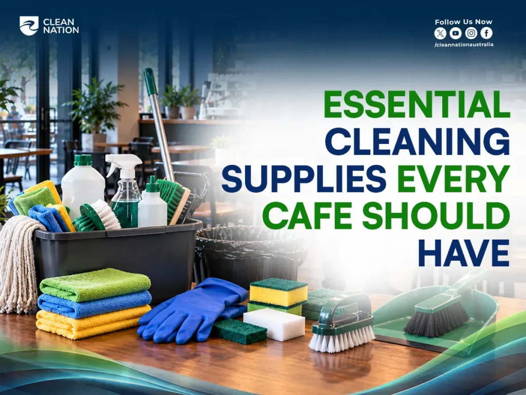 Essential cafe cleaning supplies: bucket, mop, spray bottles, microfibre cloths, scourers, gloves, scrub brushes and dustpan on a cafe table