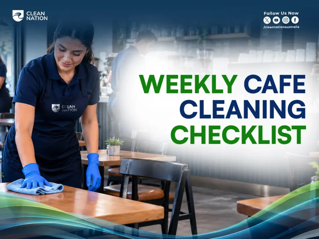 Clean Nation cleaner in an apron and blue gloves wiping a wooden cafe table as part of the weekly cafe cleaning checklist